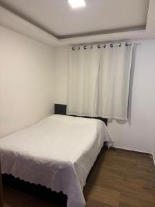 a bedroom with a white bed and a window at Flat ipojuca in Caruaru +16 photos