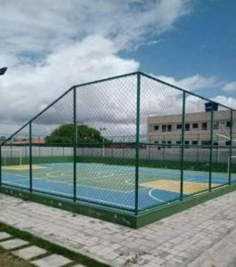 a tennis court behind a chain link fence at Flat ipojuca in Caruaru