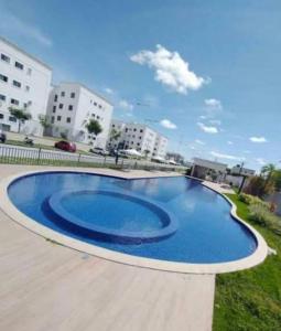 a large blue swimming pool with buildings in the background at Flat ipojuca in Caruaru