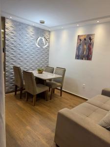 a dining room with a table and chairs and a painting at Flat ipojuca in Caruaru