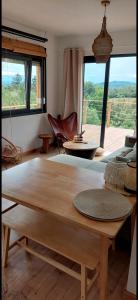 a living room with a table and a large window at Domek DOMiarki in Klecza