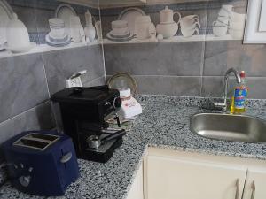 a kitchen counter with a coffee maker next to a sink at Sunny said gust house in Al Aqālitah +19 photos