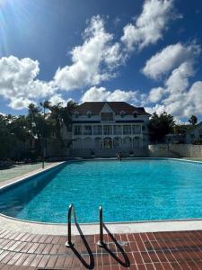 a large swimming pool in front of a house at Sea Castles La Vue in Montego Bay