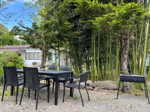 a black table and chairs with trees in the background at 竹の宿b湖まで徒歩4分の好立地最大7人宿泊可能 in Fujikawaguchiko