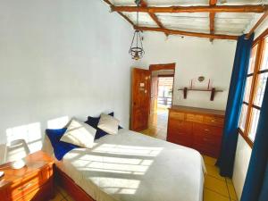 a bedroom with a large white bed with blue pillows at Black&White Brüäder in Puerto Ayora