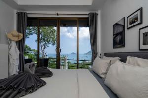 a bedroom with a bed with a view of the ocean at Harbour View Villa in Ko Tao