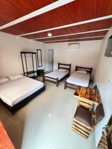 a room with two beds and a table in it at SERRANTE Hotel Campestre in Villavicencio