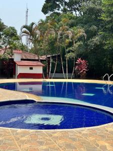 a swimming pool with a fountain in a yard at SERRANTE Hotel Campestre in Villavicencio