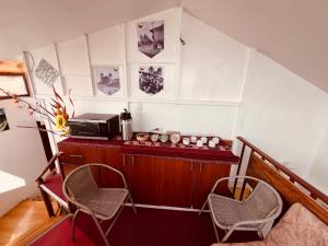 a room with a counter with two chairs and a microwave at PAKARI Wasi in Cusco