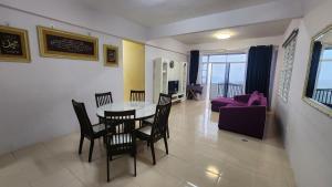 a living room with a table and chairs and a purple couch at Crown imperial in Brinchang