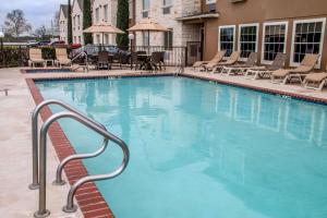 a large blue swimming pool with chairs and tables at Comfort Suites New Braunfels - San Antonio Area in New Braunfels