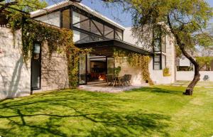 a house with a large window and a grass yard at CASA CON JACUZZI PRIVADO PARA 6 personas in Tequisquiapan