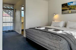 a bedroom with a bed with a picture on the wall at Recreation Hotel in Greymouth
