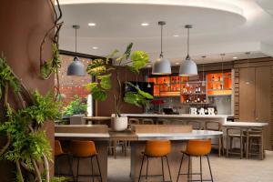 a kitchen with tables and chairs and plants at EVEN Hotel Brooklyn by IHG in Brooklyn