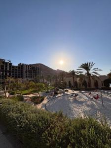 a swimming pool with the sun setting in a resort at Raha Inn Apartment in Aqaba