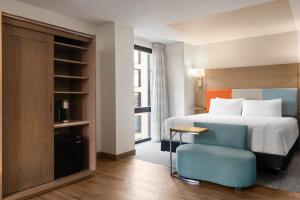 a hotel room with a bed and a blue chair at EVEN Hotel Brooklyn by IHG in Brooklyn +55 photos