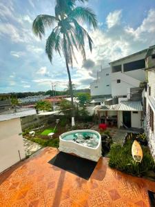 a hot tub on a patio with a palm tree at Black&White Brüäder in Puerto Ayora