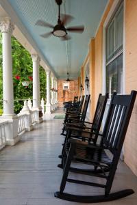 una fila di sedie seduta sul portico di una casa di 200 South Street Inn a Charlottesville