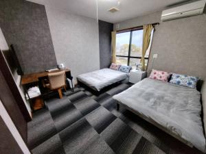 a hotel room with two beds and a desk and a desk at 五島宿Seina in Goto