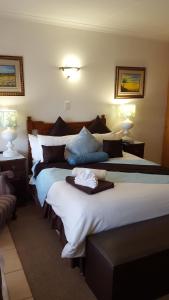 a hotel room with two beds and two lamps at Boschdal Upmarket Guesthouse in Rustenburg +96 photos