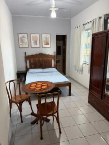a bedroom with a bed and a table and chairs at Hostel Alto do Rosario in Vitória