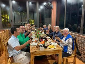a group of people sitting around a table eating food at Ngan Nga in Bắc Hà
