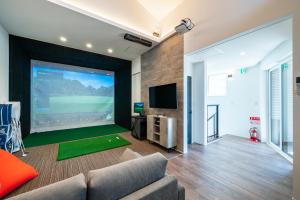 a living room with a large projection screen at YUTORELA 富津 indoor GOLF シミュレーションゴルフ付き l BBQ l ファミリー歓迎 in Futtsu