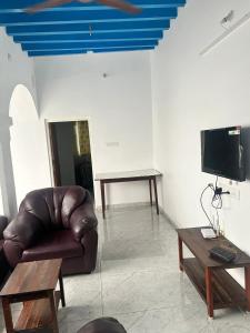 a living room with a brown leather couch and a table at La Maison D&N in Pondicherry