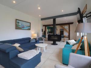 a living room with blue couches and a fireplace at Maison ancienne avec sauna et jeux au cœur du Perche - FR-1-497-51 in Moussonvilliers