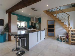 a kitchen with a counter and a staircase in a room at Maison ancienne avec sauna et jeux au cœur du Perche - FR-1-497-51 in Moussonvilliers