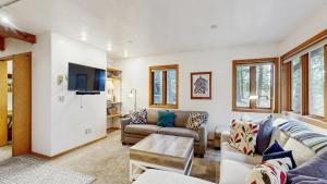 a living room with a couch and a tv at Cozy A-Frame Cabin in Downtown McCall in McCall +12 photos