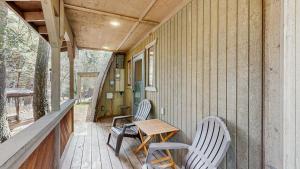 two chairs and a table on the porch of a house at Cozy A-Frame Cabin in Downtown McCall in McCall