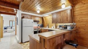 a kitchen with wooden cabinets and a white refrigerator at Cozy A-Frame Cabin in Downtown McCall in McCall