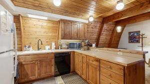 a kitchen with wooden cabinets and a refrigerator at Cozy A-Frame Cabin in Downtown McCall in McCall