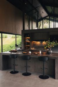 a kitchen with a counter with two stools in it at Spring River Cisarua in Paragajen
