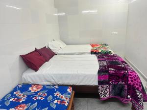 a small room with two twin beds with colorful blankets at La Maison D&N in Pondicherry