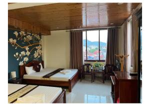 a bedroom with two beds and a large window at Ngan Nga in Bắc Hà