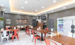 a restaurant with wooden tables and red chairs at Incheon Pentastar Hotel in Incheon
