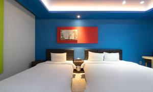 two beds in a room with blue walls at Incheon Pentastar Hotel in Incheon