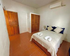 a bedroom with a bed with two towels on it at BLACK&WHITE -Dis Dihai- in Puerto Ayora