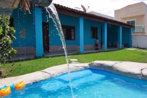a water fountain in front of a blue house at Casa com Piscina Privativa e Churrasqueira in Araruama