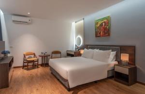 a bedroom with a large white bed and a table at Luxe Paradise Hotel Truc Bach in Hanoi