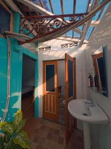 a bathroom with a sink and a room with a door at Laura's Backpacker 523 in Yogyakarta