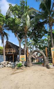 a resort with palm trees and a sign in the sand at Villas Manchineel in Sayulita
