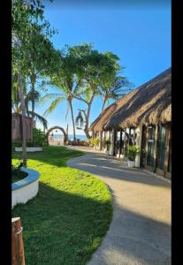 a path leading to a resort with palm trees and the ocean at Villas Manchineel in Sayulita +4 photos