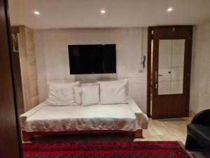 a bed with white pillows and a flat screen tv at Studio Verde in Au