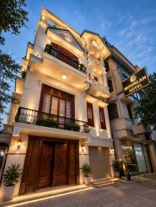 a large white building with a sign in front of it at Moonland Hotel in Phương Lăng