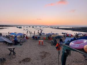 a crowd of people on a beach at sunset at Cabanon plage david in Bouznika