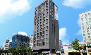 a tall building with a clock on it in a city at Dobong Hotel Bay204 in Seoul