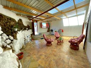a room with chairs and a stone wall at BLACK&WHITE -Dis Dihai- in Puerto Ayora